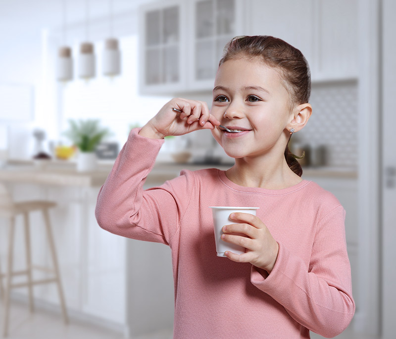 kleines Mädchen isst Joghurt